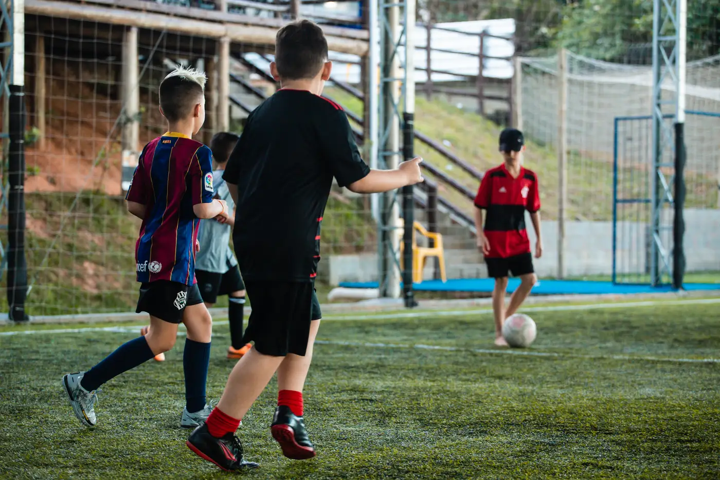 Crianças jogando futebol na quadra society Arena Bate Bola São José SC